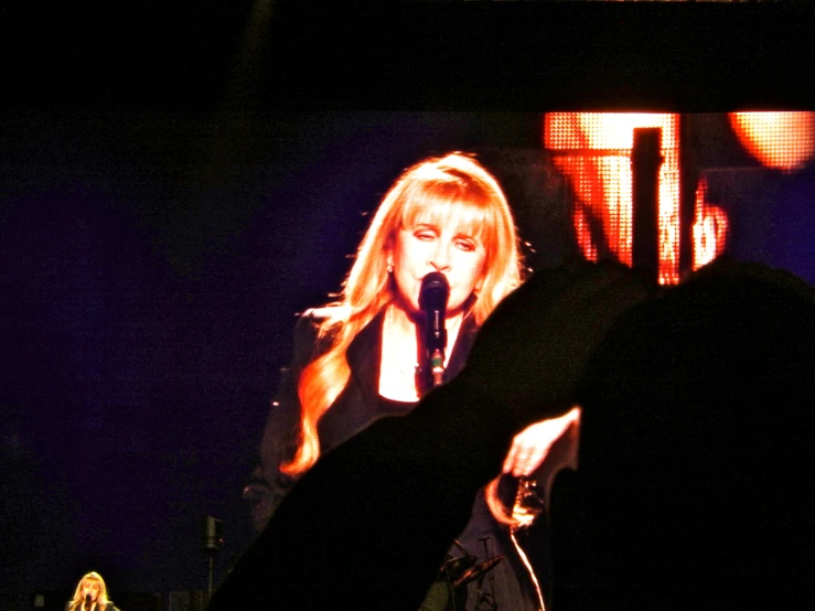 a woman standing in front of a big screen with an image on it