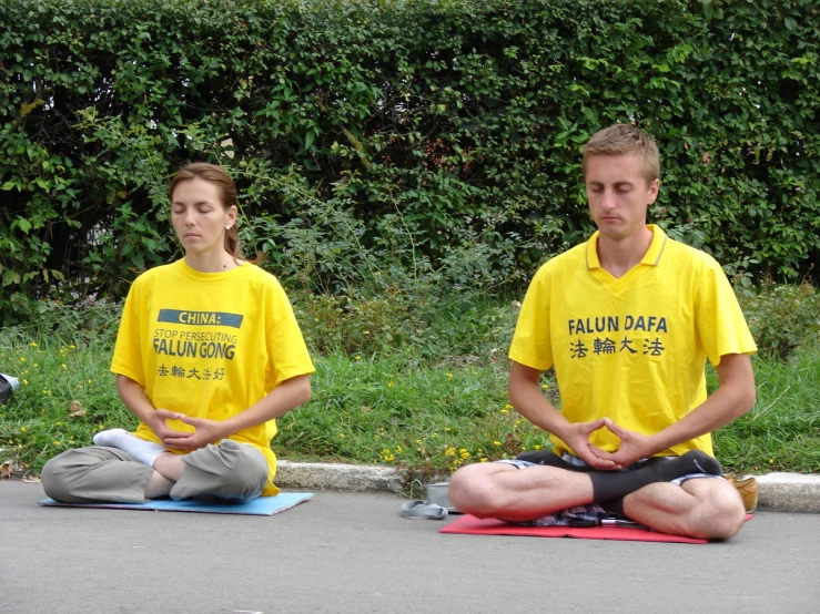 two men are sitting on their stomachs in yoga mats