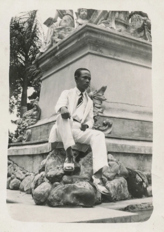 the man is sitting on a small rock