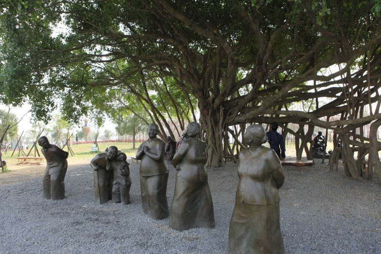 sculptures on the gravel under the large tree