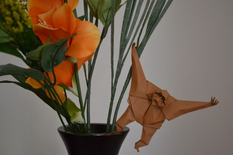 there is an origami crane near some flowers