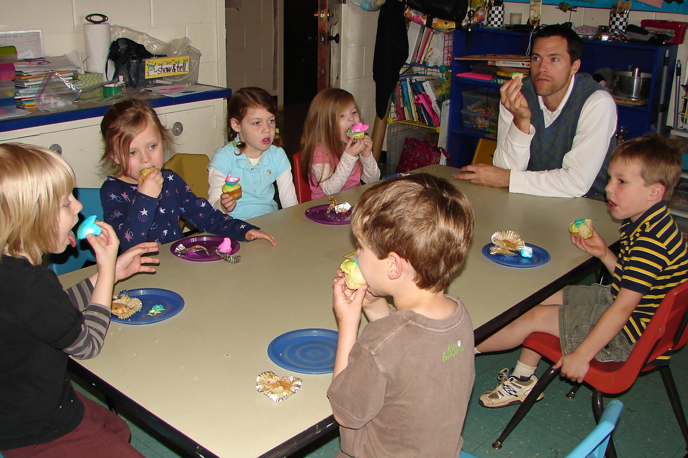 a group of children sitting at a table together