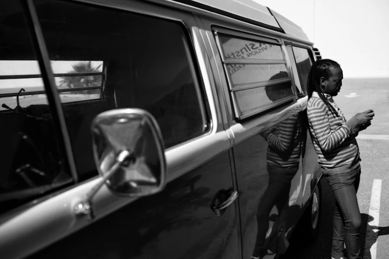 a black and white po of two people standing by a car