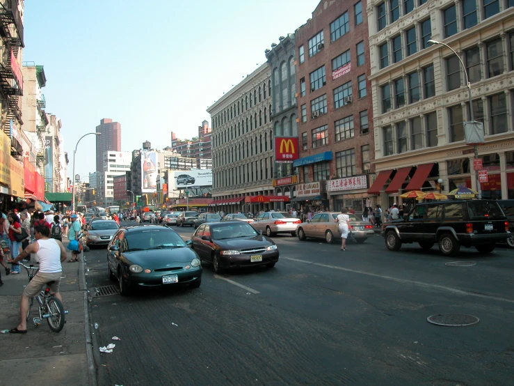 a crowded street with traffic, people and vehicles