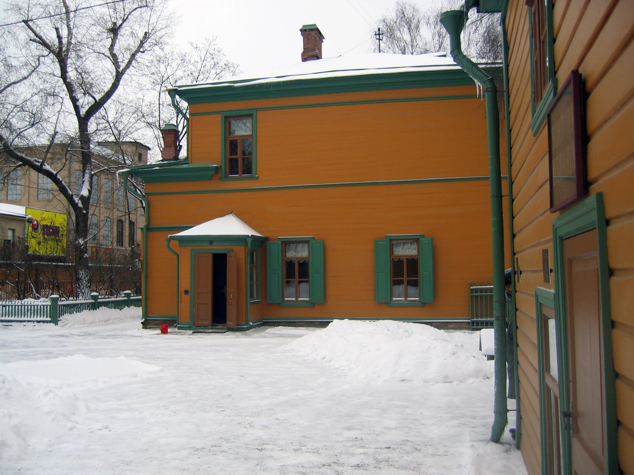 a house with green trim and green shutters covered in snow