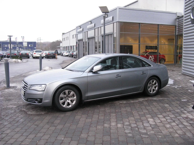 an audi car parked in front of a brick shop