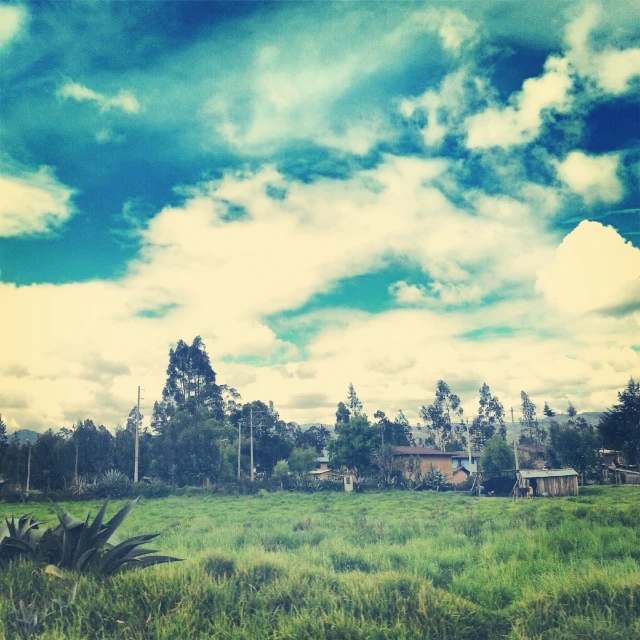 a farm and its pasture under a cloudy sky