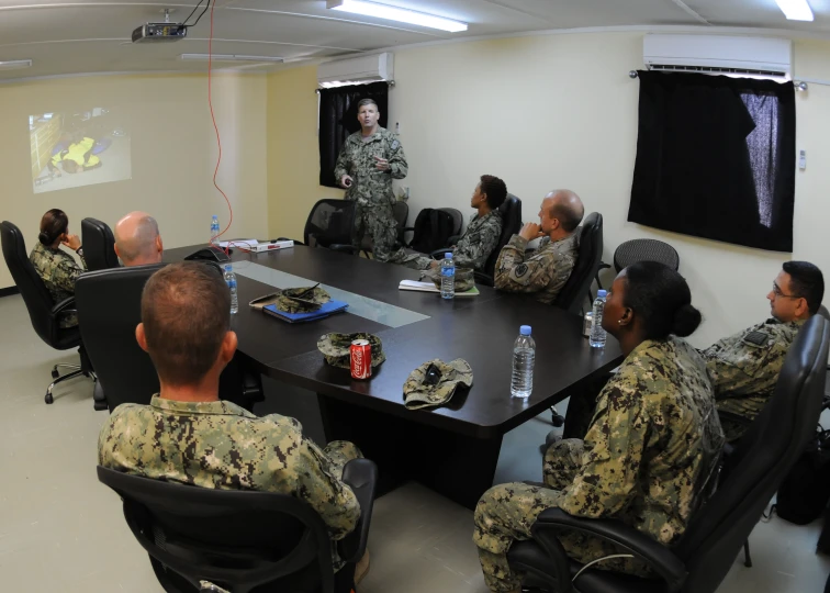 soldiers sitting around a black table in a room