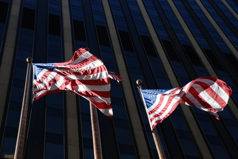 three american flags are flying outside a building