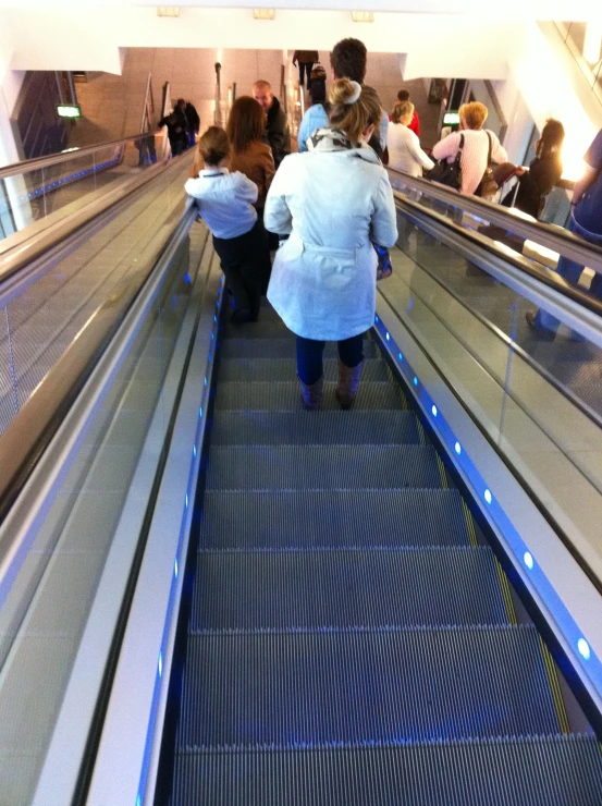 a group of people riding down an escalator on an escalator