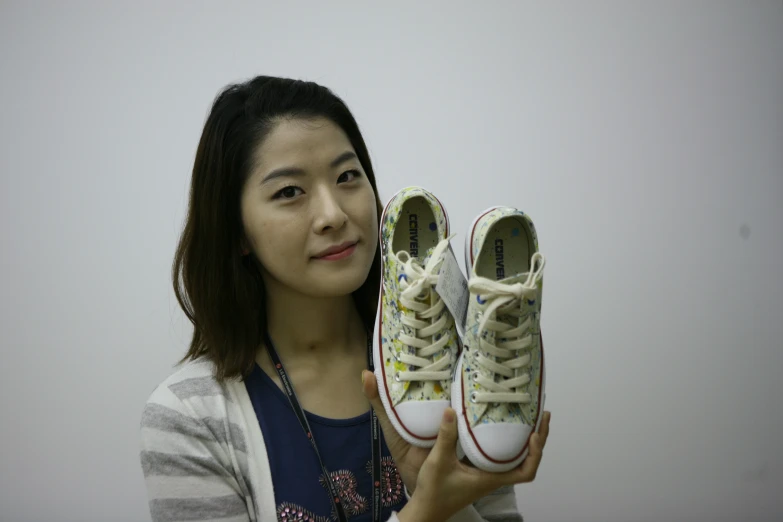 a girl posing with her sneakers and a book