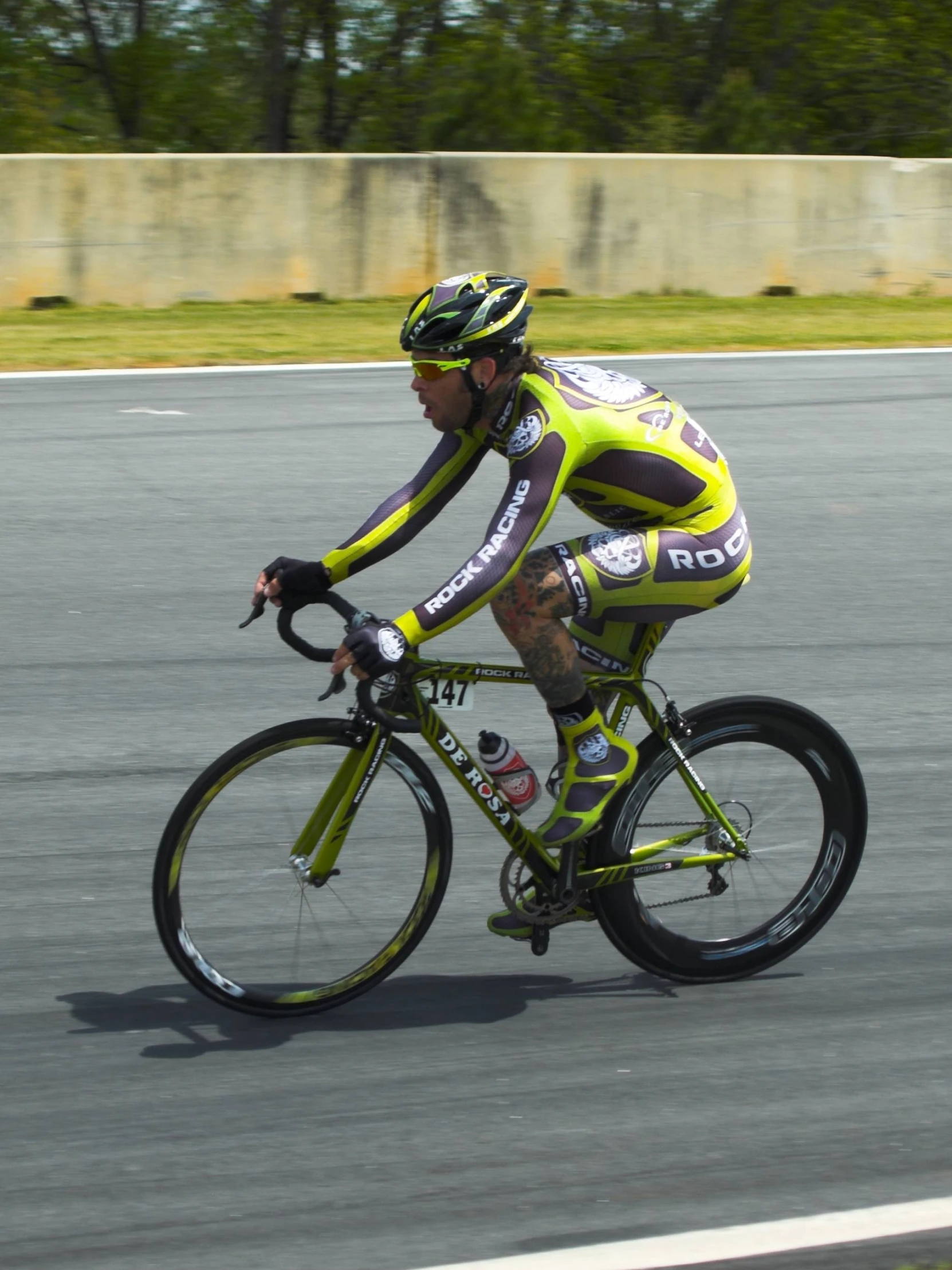 a man riding on the back of a bicycle on a road