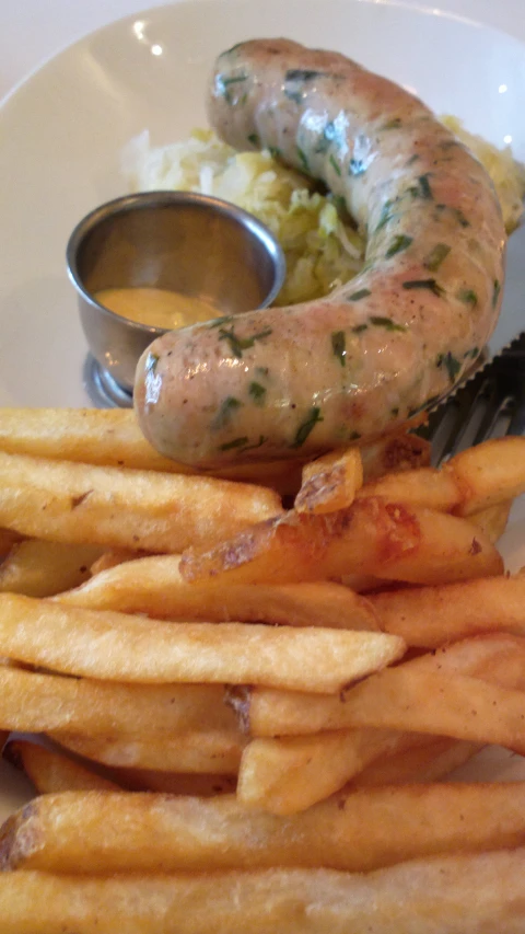 fried sausage on a plate with some fries and mashed potatoes