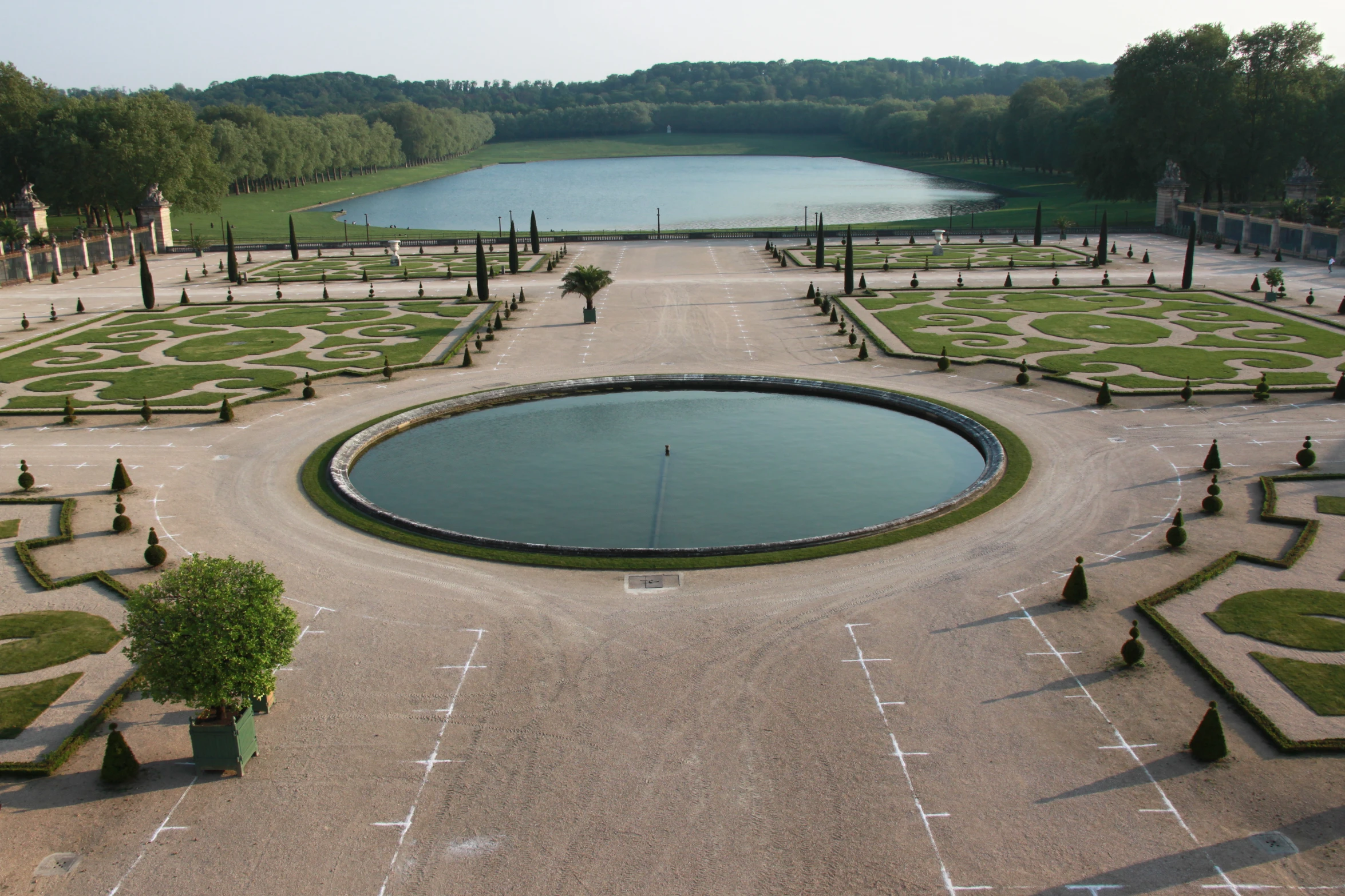 a small circular park has a pond surrounded by trees