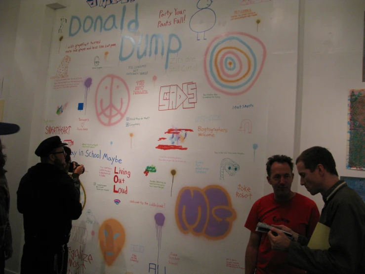 a group of people are standing in front of a white board that has writing on it