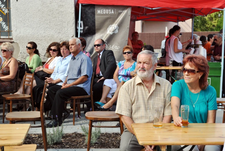 people sitting at tables during an outdoor event