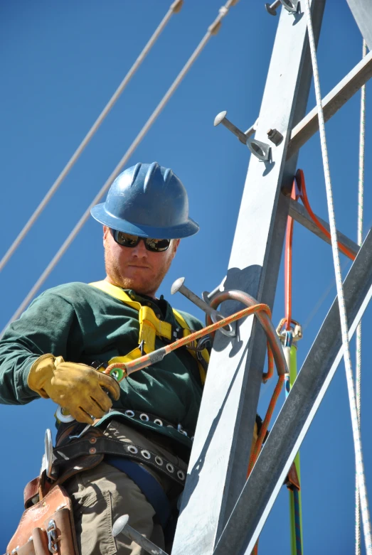 the construction worker is holding the rope of the crane