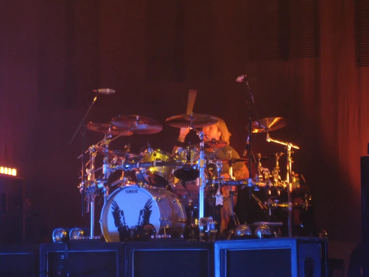 a drum set sitting in front of a big screen