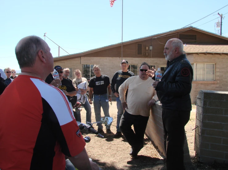 a group of people talking in front of a house