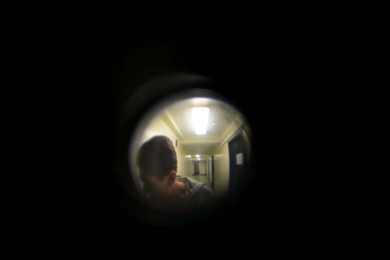 a person in a dark room is through a round window