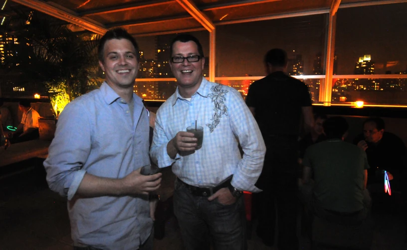 two men stand side by side and pose for the camera