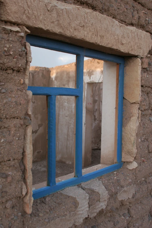 a window with some blue frames in an old building