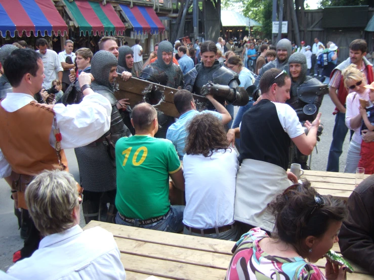 people gathered around an outdoor setting playing tug of war