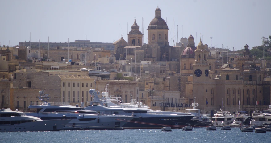 several boats docked in a harbor next to a big city