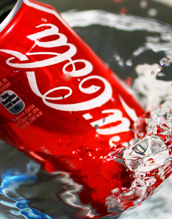 a water - filled red soft drink can is in some water