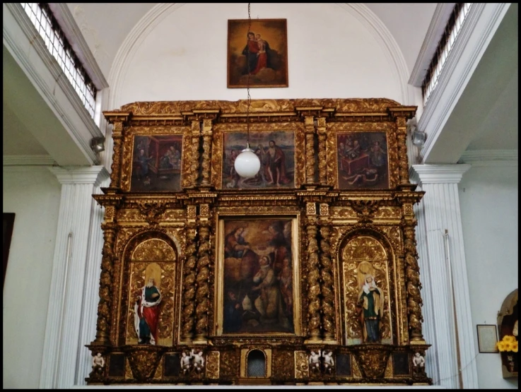 a large wooden alter with paintings hanging in it's walls