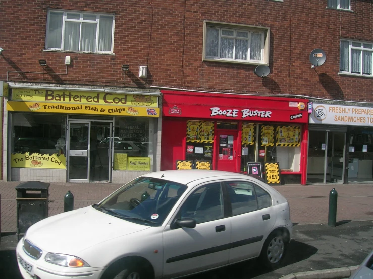 a small white car is parked outside the business