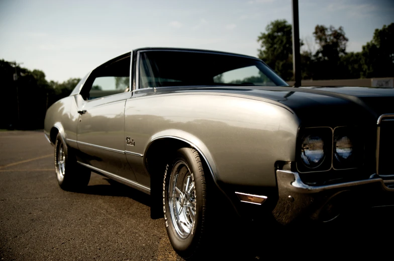 a silver old ford mustang sitting on the side of a road