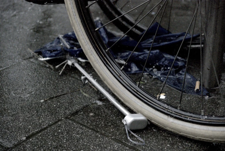 the tire of a bicycle sits next to a piece of tarp
