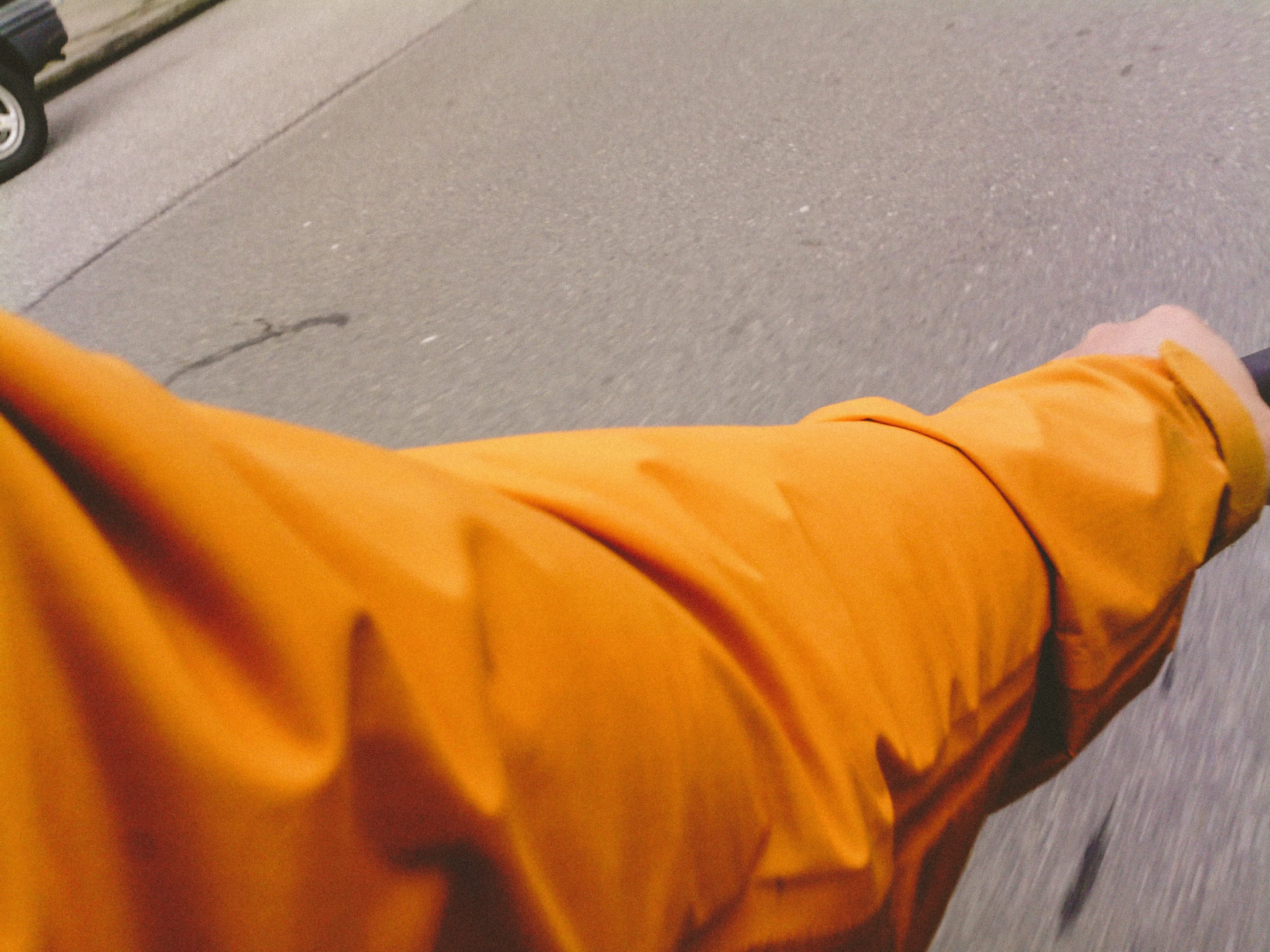 person wearing yellow outfit and hat standing by sidewalk