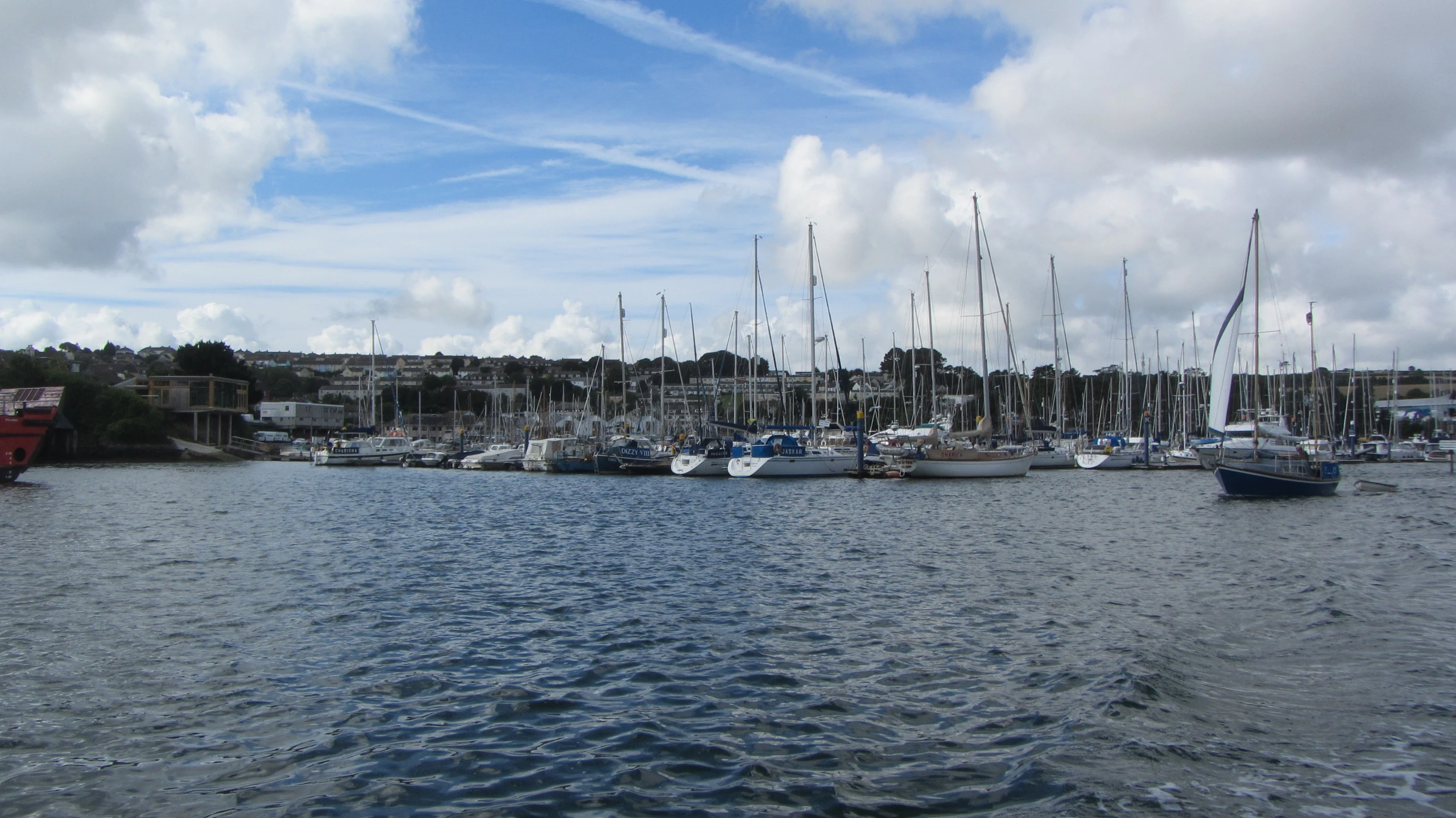 sail boats are parked on the dock in a large harbor