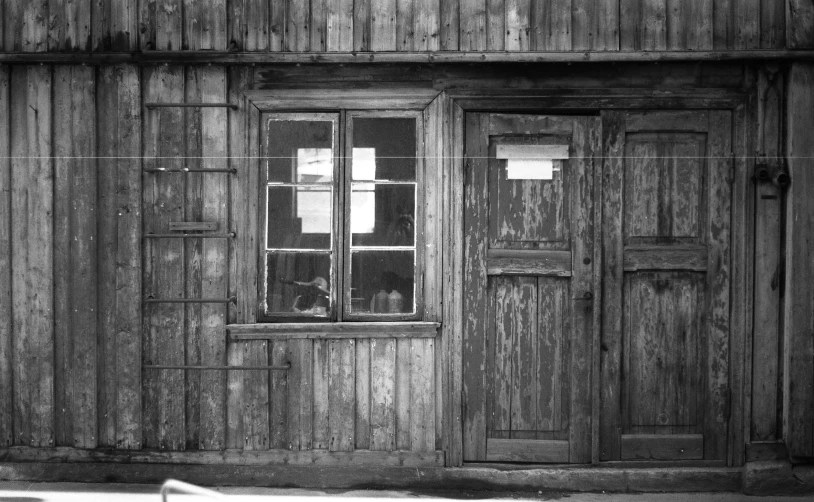 a cat is sitting in the window on the side of a building