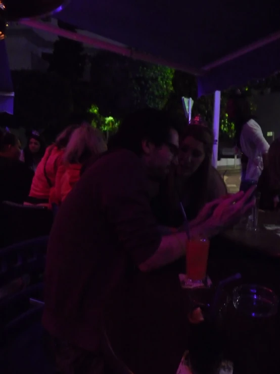 a man and woman standing by each other in a dimly lit area