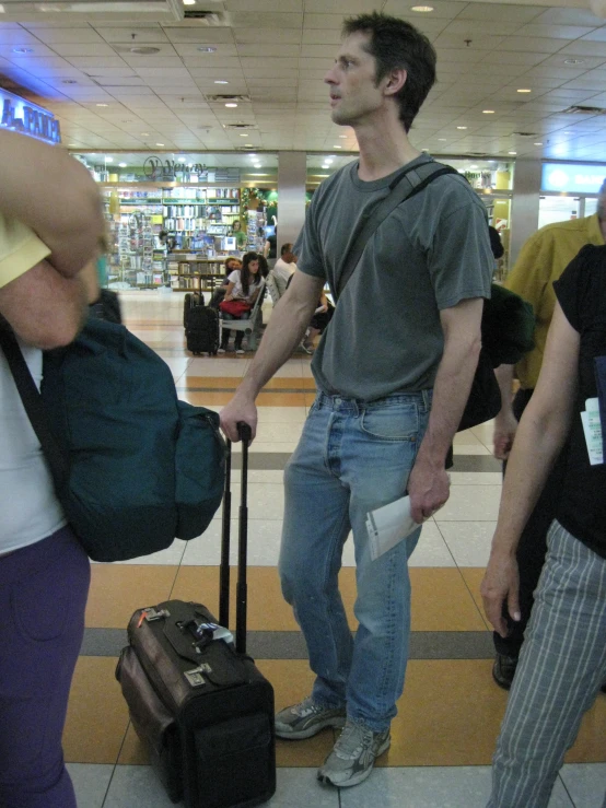 a man that is holding some luggage near him