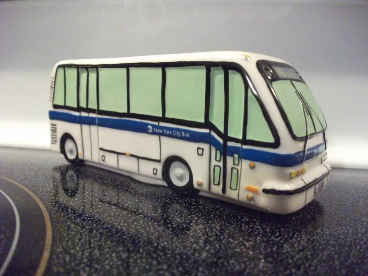 a model bus on a dark table with white and blue trim