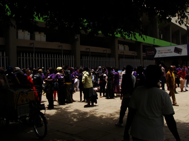 a group of people walking past tall buildings