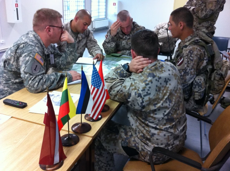 a group of soldiers sitting at a long table