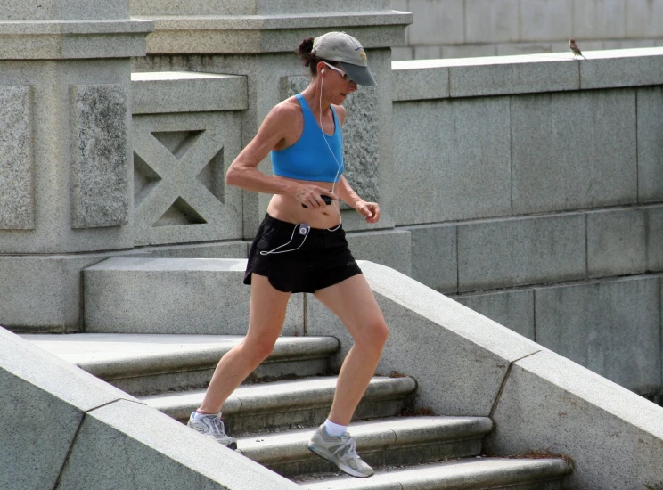 a woman jogging up stairs towards the water