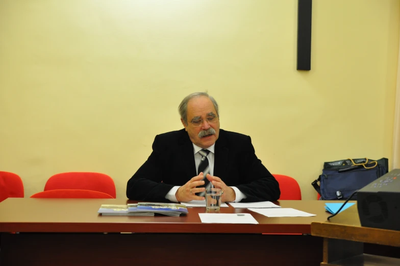 a man in black jacket sitting at a table