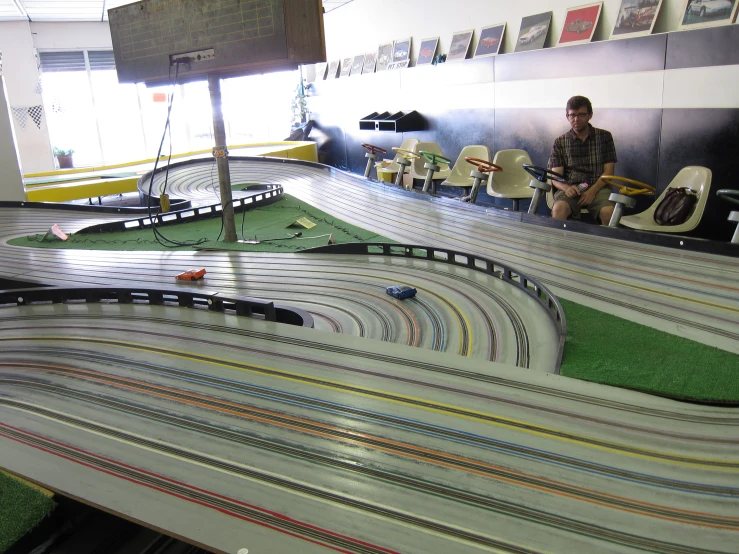 man playing the guitar for some very long model trains