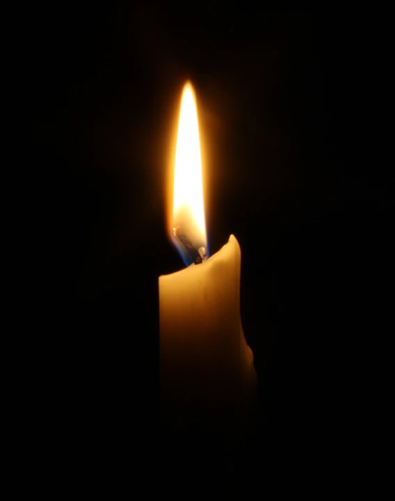 a candle lit in the dark on a dark background