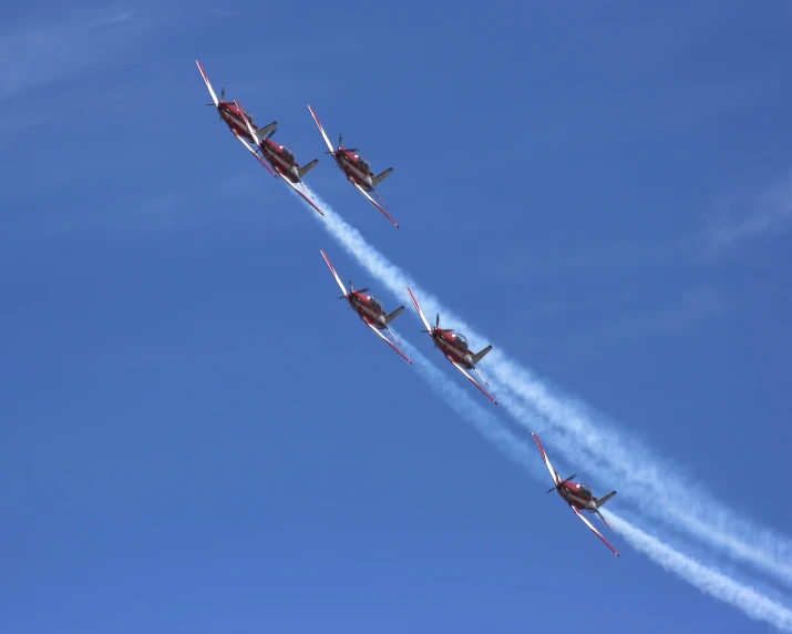 four fighter jets are flying through the air