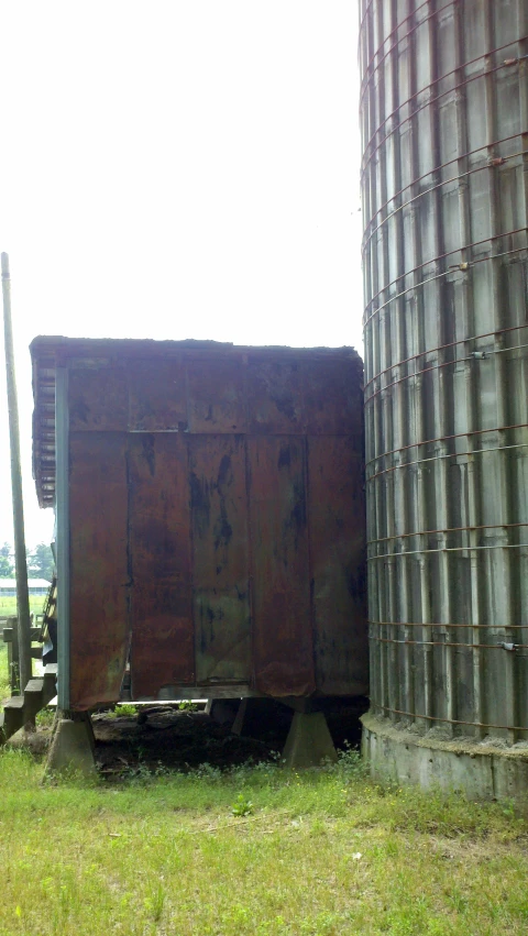 a large piece of wood sitting next to a silo