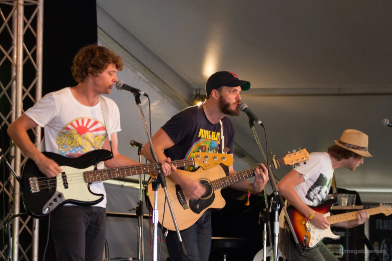 some guys playing guitars while wearing hats