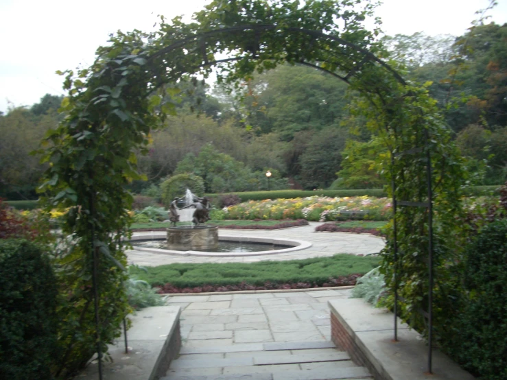 a fountain is surrounded by various plants and flowers