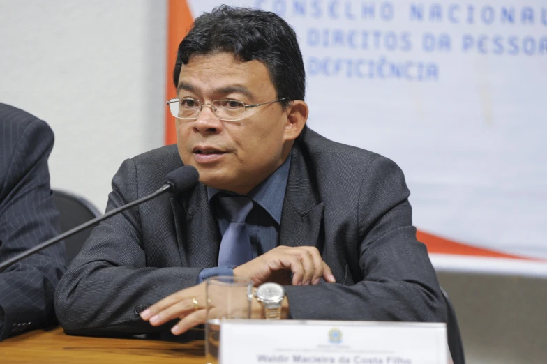 a man sitting at a table holding a glass